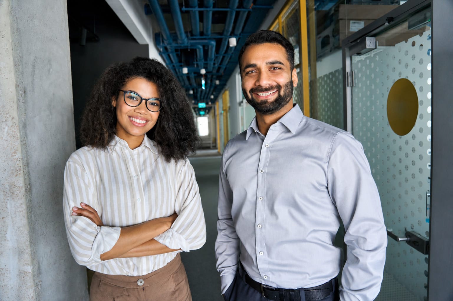 Deux jeunes cadres souriants en entreprise, illustrant le recrutement dans les métiers en tension en Outre-Mer